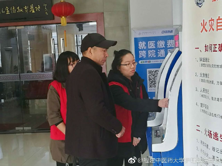志愿者在教病人使用自助机2.jpg