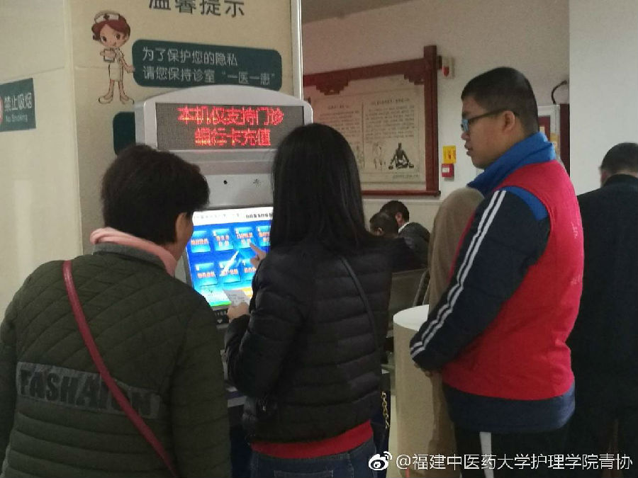 志愿者在教病人使用自助机.jpg